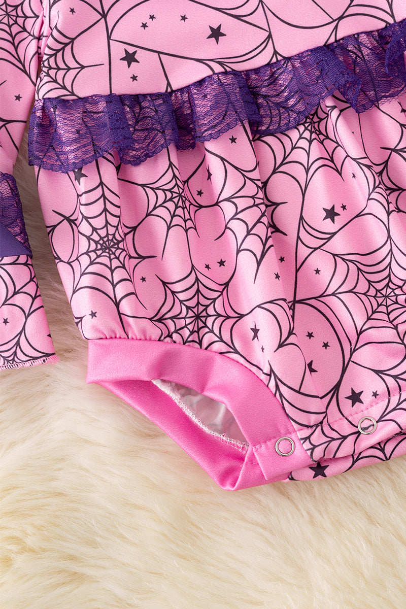 Spider web printed on pink baby onesie with purple lace and bell sleeves.