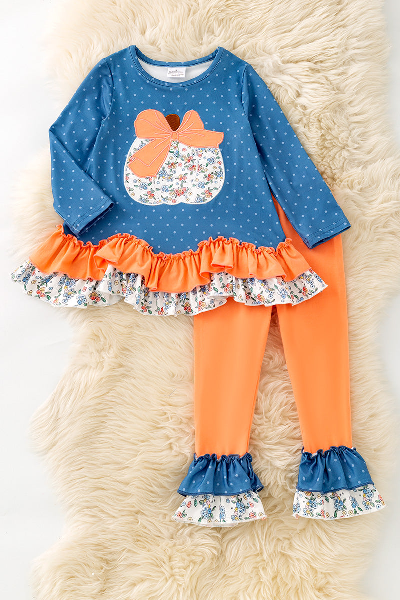 Blue top w/white polka dot & ruffle hem and orange pants. OFG61765