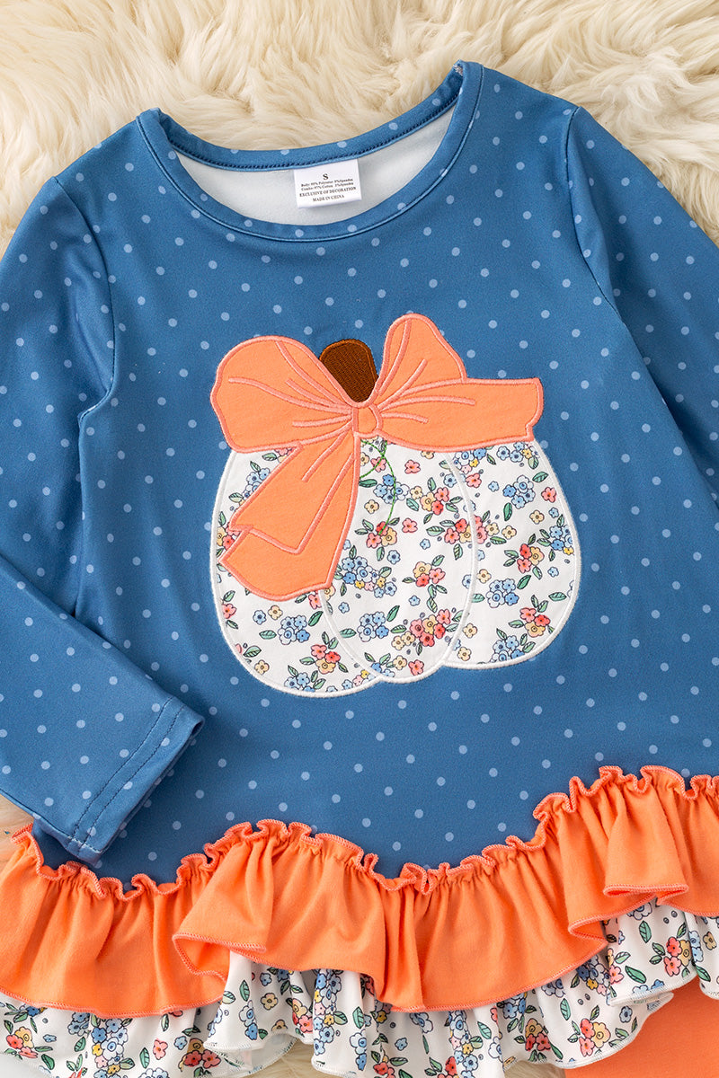 Blue top w/white polka dot & ruffle hem and orange pants. OFG61765