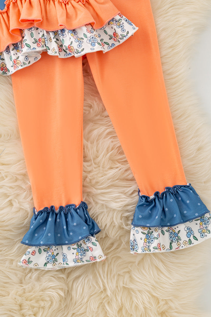 Blue top w/white polka dot & ruffle hem and orange pants. OFG61765