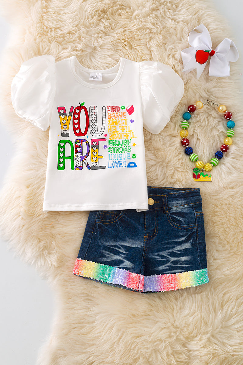 "You are kind, brave" white top w/ bubble sleeves and denim shorts.