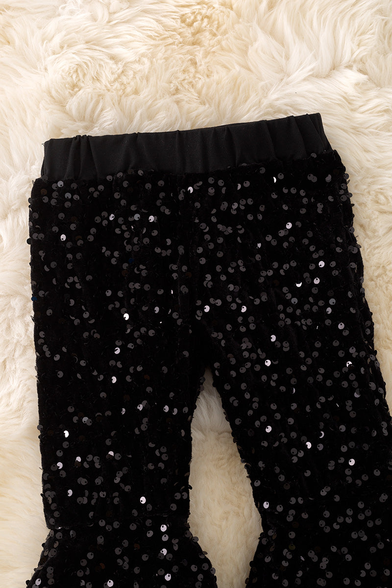 Black sequins bell bottoms with fur trim.