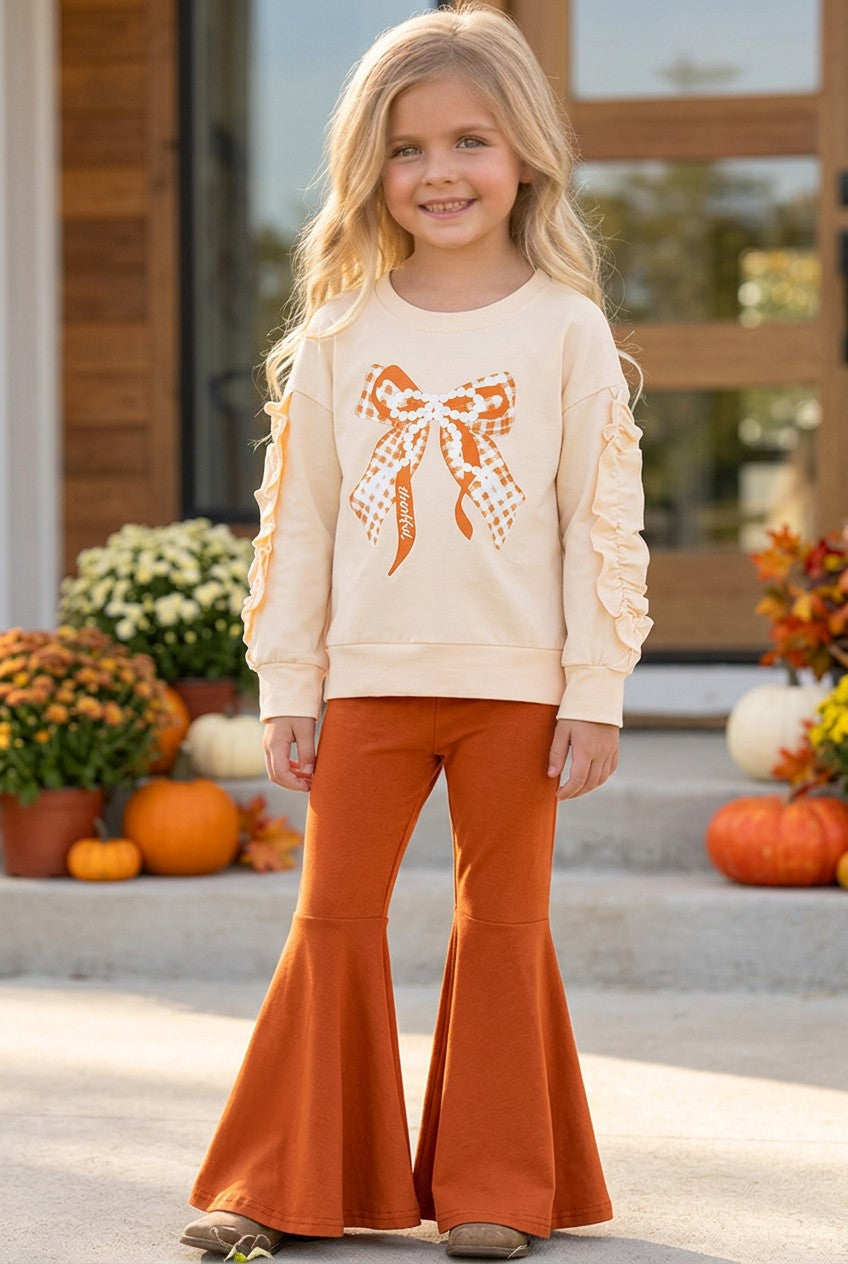 Pearl Bow printed on cream sweatshirt w/ ruffle and rust orange bell bottoms. OFG61417 SOL