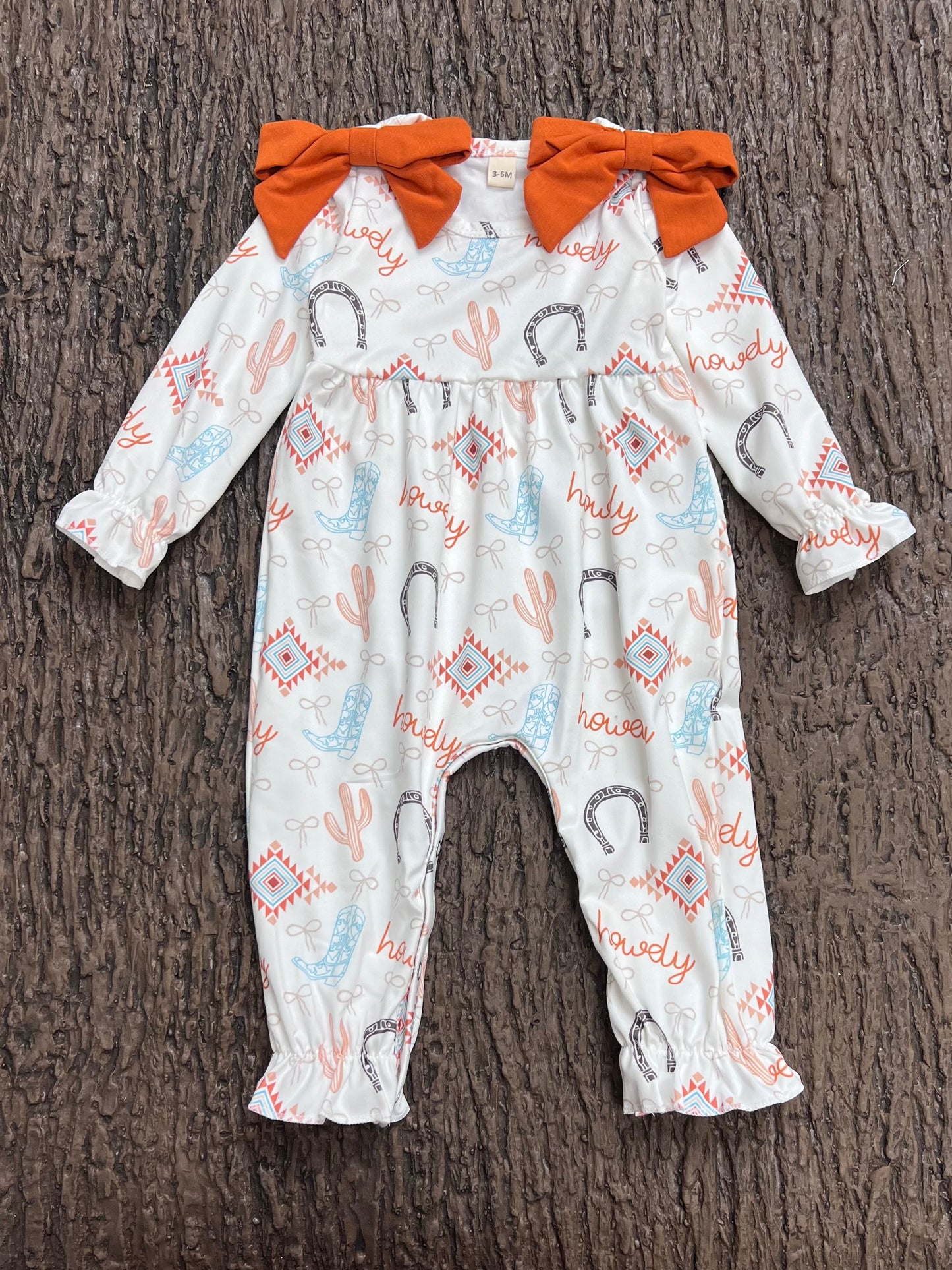 Howdy" printed girls baby romper w/rust side bows. A2026-S-