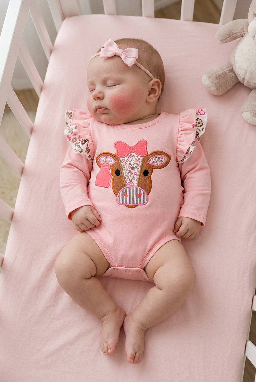 Pink cow applique baby bodysuit with floral ruffle on sleeves and ruffle butt. RPG61924 SOL